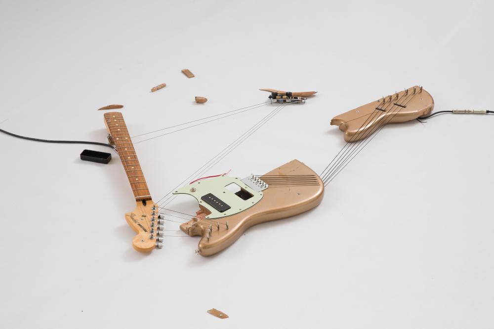 Naama Tsabar: „Melody of Certain Damage #22“, 2022, zerbrochene E-Gitarre, Saiten, Metall,  Schrauben, Mikrofone, 122 x 112 x 7 cm